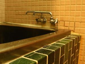 a sink with a faucet in a bathroom at 民宿 朝富士 in Yamanakako