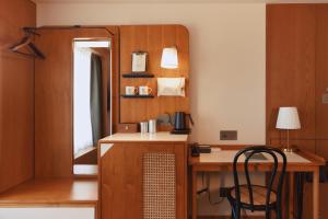 Zimmer mit einem Schreibtisch, einem Stuhl und einem Spiegel in der Unterkunft 天下南隅 Provintia Hotel in Tainan