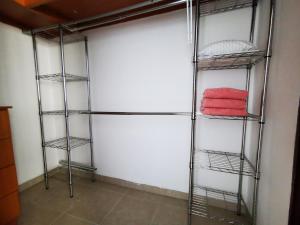 a walk in closet with four iron shelving at Habitación privada en zona exclusiva in Panama City