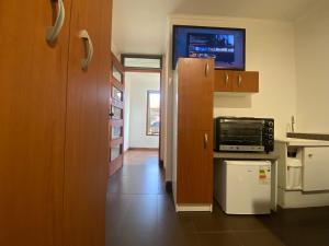 a kitchen with a refrigerator and a microwave at Hospedaje Regina in Santiago