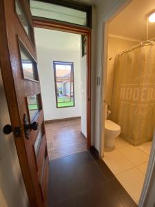 a bathroom with a toilet and a window and a door at Hospedaje Regina in Santiago +22 photos