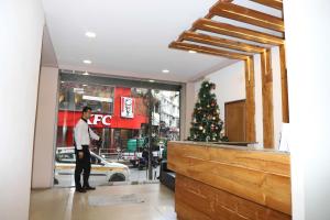 a man standing in front of a store window with a christmas tree at The Grand Hotel in Āīzawl