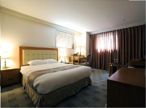 1 dormitorio con 1 cama grande en una habitación de hotel en Daegu AW Hotel, en Daegu