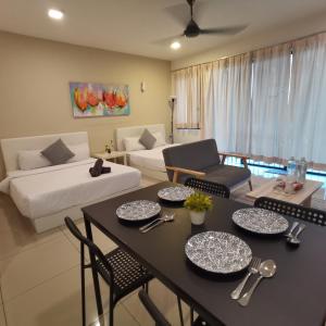 a living room with a table and chairs and a couch at NH Homestay Trefoil Setia Alam in Shah Alam