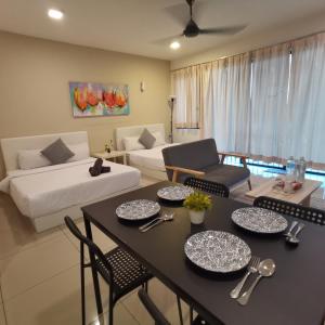 a living room with a table and chairs and a couch at NH Homestay Trefoil Setia Alam in Shah Alam