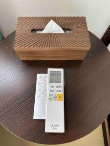 une télécommande et une boîte sur une table dans l'établissement Yoshimura igariya, à Azagawa