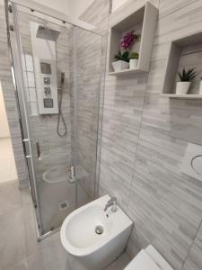 a bathroom with a shower and a toilet and a sink at Le Case del Cortile in Catania