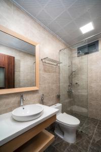 a bathroom with a sink and a toilet and a mirror at May Home Apartment Da Nang in Da Nang