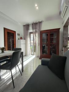 a living room with a table and chairs and a kitchen at Le Case del Cortile in Catania