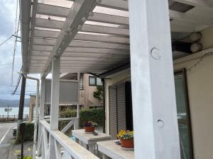 a porch with awnings and potted plants at 民宿 朝富士 in Yamanakako