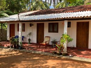a house with a chair in front of it at Lake House Homestay in Anuradhapura