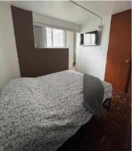 Schlafzimmer mit einem Bett und einem Fenster in der Unterkunft Habitación económica y pequeña con baño privado cerca del Centro Histórico in Mexiko-Stadt