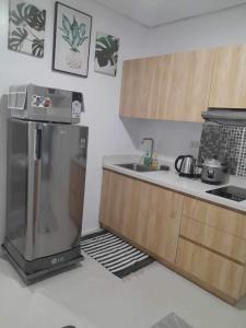 a kitchen with a refrigerator and a sink at The Hideaway at Citta Verde Primavera City in Cagayan de Oro