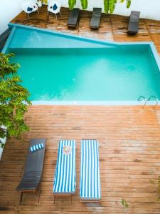 una piscina con due sedie a sdraio e una piscina di Bella Vita ad Aluthgama