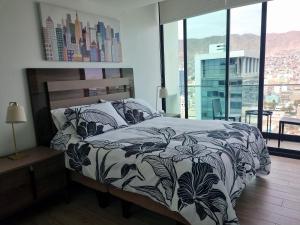 Schlafzimmer mit einem Bett mit einer schwarzen und weißen Bettdecke in der Unterkunft Antofagasta Inolvidable in Antofagasta