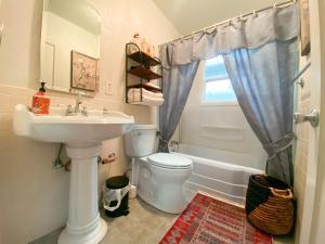 een badkamer met een wastafel, een toilet en een raam bij Private House in Sacramento. Only 2mins to Freeway! in Sacramento