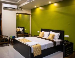 1 dormitorio con 1 cama con pared verde en Faiz Residency en Rāmanāthapuram