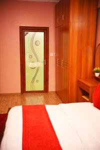a bedroom with a bed and a door with a window at Beauty Homes Kilimani in Nairobi