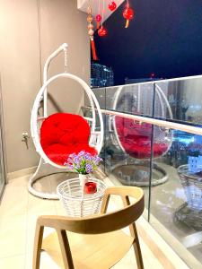 una silla con asiento rojo y una mesa con flores en CONDOTEL 5 SAO THE SÓNG VŨNG TÀU Mr VƯƠNG VIP en Vung Tau