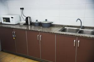 a kitchen counter with a sink and a microwave at Beauty Homes Kilimani in Nairobi