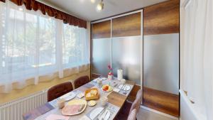Silver Zsóry Apartman في ميزوكوفسد: غرفة طعام مع طاولة ونافذة كبيرة