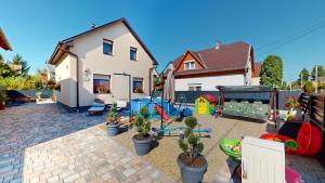 a backyard with potted plants and a house at Silver Zsóry Apartman in Mezőkövesd