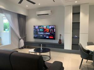 a living room with a tv on a wall at Luxe J Homestay in Taiping