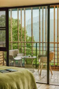 a bedroom with a bed and a balcony with a view at Moganshan Spring Mountain View B&B in Deqing