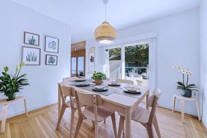 a white dining room with a table and chairs at Three-Tree Villa-Central Location in Vancouver