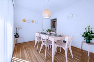 a white dining room with a white table and chairs at Three-Tree Villa-Central Location in Vancouver
