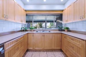 a kitchen with wooden cabinets and a sink at Three-Tree Villa-Central Location in Vancouver
