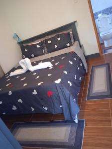 ein Bett mit einer schwarzen Bettdecke mit Herz drauf in der Unterkunft Sarah's Garden BnB & Spa in Clarin