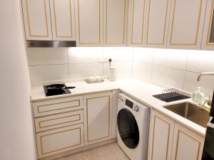 a kitchen with a washing machine and a sink at The Ress - The Axon Bukit Bintang Residence in Kuala Lumpur
