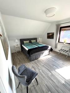 a bedroom with a bed and a chair and a window at Ferien-Whg Stünkel nahe Steinhuder Meer mit Garten und Balkon in Steinhude