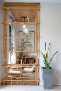 a wooden shelf with a mirror and a potted plant at Moganshan Spring Mountain View B&B in Deqing