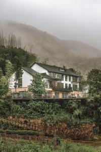 a house on top of a hill with a bridge at Moganshan Spring Mountain View B&B in Deqing