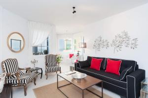 a living room with a black couch and red pillows at Chic 3BR Apt w Parking on the Beach by Sea N' Rent in Tel Aviv