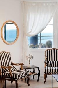 a living room with two chairs and a window at Chic 3BR Apt w Parking on the Beach by Sea N' Rent in Tel Aviv