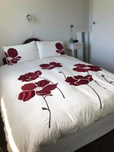 a bedroom with a bed with red flowers on it at Horseinaround in Cambridge