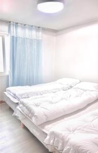 2 camas blancas en una habitación con ventana en A-one en Seúl