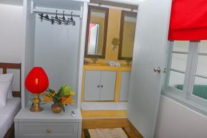 una camera con un letto e una lampada rossa su un tavolo di Khalid's Guest House a Galle