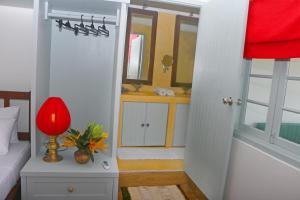 a bedroom with a bed and a red lamp on a table at Khalid's Guest House in Galle