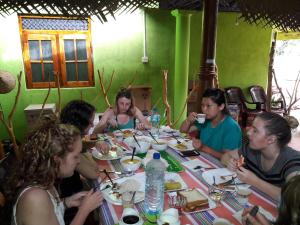 a group of people sitting around a table eating food at Big House Udawalawe in Udawalawe