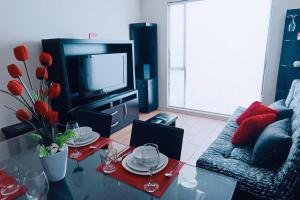 un soggiorno con tavolo e TV di Secure, central and quiet apartment work or travel a Città del Messico