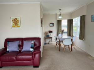 a living room with a red leather couch and a table at Glenview home in Hamilton