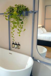 a bathroom with a tub and a plant in a mirror at Heart Hotel in Limassol