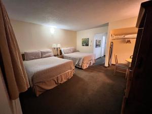 um quarto de hotel com duas camas e uma mesa em Timbers INN and Suites em Ashland