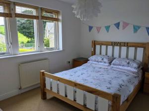 a bedroom with a wooden bed and two windows at Detached 4 Bedroom Luxury Home in Halifax