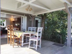 eine Veranda mit einem Tisch und Stühlen auf einer Terrasse in der Unterkunft Au Temps Suspendu - 3 chambres - Au coeur de la nature - À 10 minutes des commerces in Vielle-Tursan