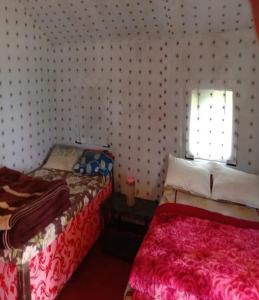 a bedroom with two beds and a window at Camping at Serene Chopta in Sari